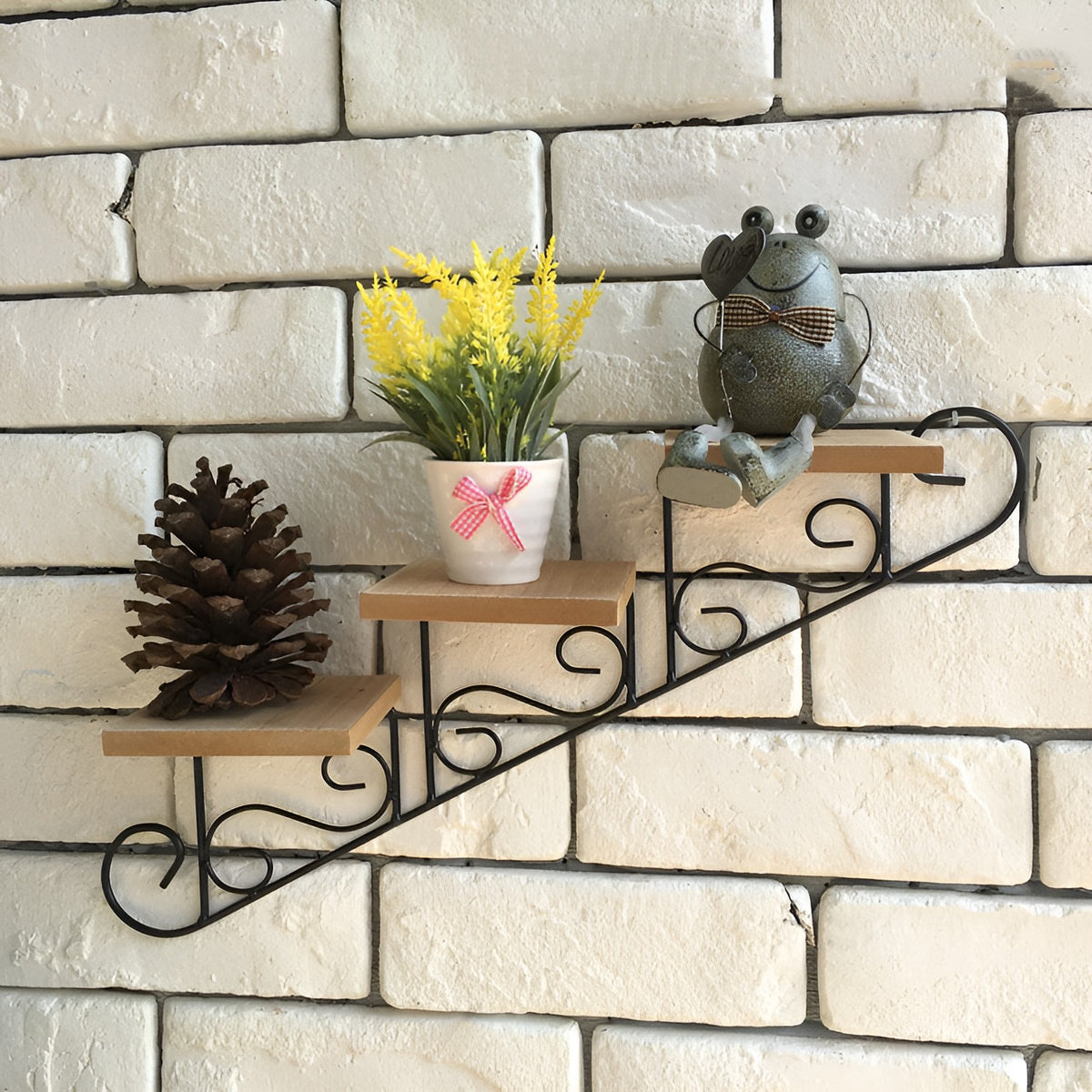 Close-up of a wrought iron stair-step wall shelf with scrolled metal frame and three wood shelves